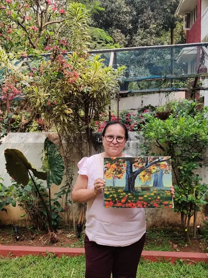 A proud artist with her finished piece. This student captured a lovely park scene using a blur technique and impasto style during our adult art class.