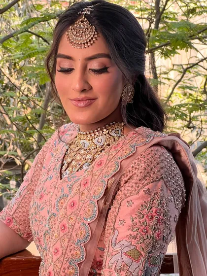 A close-up of the pastel bride, showing the soft, romantic waves and how they frame her face and maang tikka.