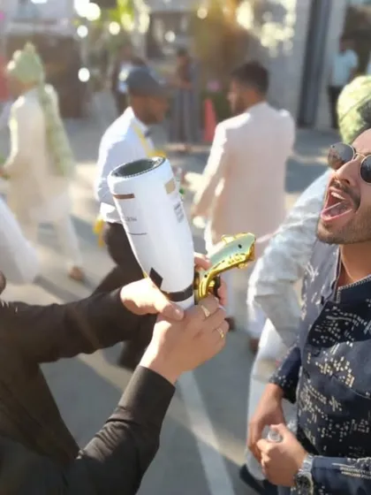 Taking the party to the streets. Our founder uses a shot gun to serve drinks during a wedding 'baraat', showing how we can adapt our service to any part of the celebration.