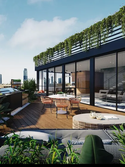 A view of a completed rooftop terrace project, integrating a glass-walled sunroom with an open deck and lush greenery. This design creates a true urban oasis, blending modern architecture with natural elements high above the city.