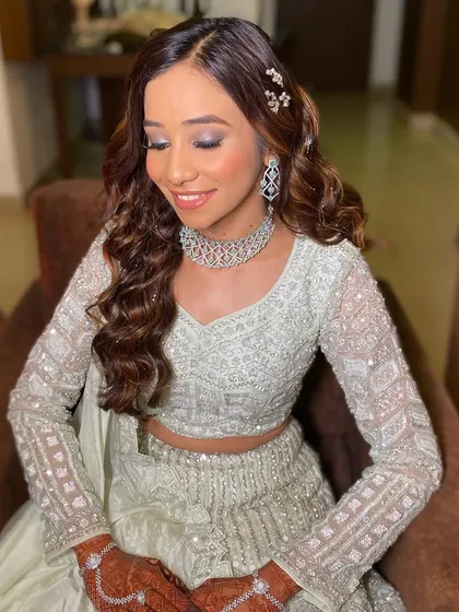 A close-up of the bride's shimmery eye makeup. The soft, cool tones perfectly match her elegant outfit.