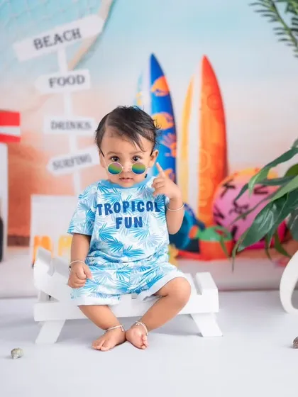 A playful moment with sunglasses during a tropical-themed first birthday shoot. We capture the fun and silly expressions that make your child unique.