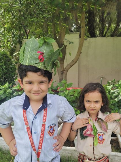 Two students proudly wear their handmade nature crowns and necklaces for Van Mahotsav. This activity allows them to connect with nature creatively and appreciate its beauty.