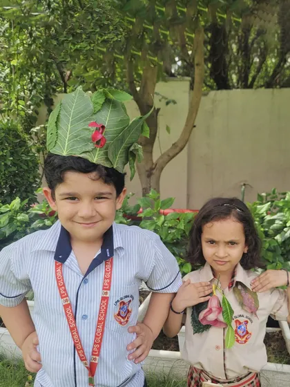 Two students proudly wear their handmade nature crowns and necklaces, spreading the message of environmental conservation with joy.