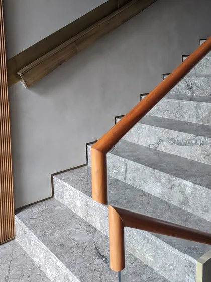The junction of the wooden handrail on the marble staircase at the Bammi Residence. Every detail is considered to ensure a seamless and tactile experience as one moves through the home.