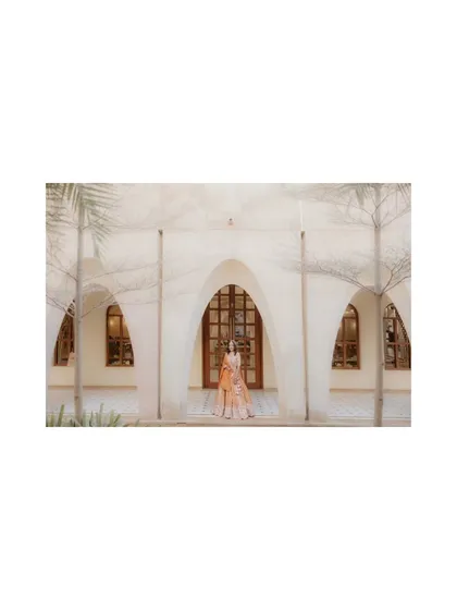 A wide, artistic shot of the bride standing before a grand archway. I use architectural elements to create dramatic and memorable bridal portraits.