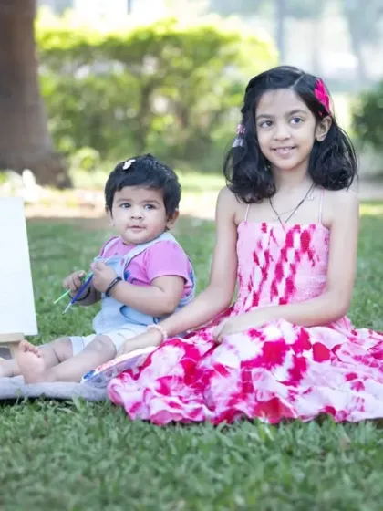 A big sister helps her baby sister with an art project. Sibling photoshoots are a wonderful way to document their growing friendship and the special bond they share.