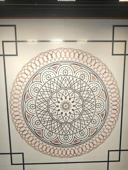 A geometric mandala design with copper inlay on white stone. This piece combines traditional patterns with modern materials for a timeless look.