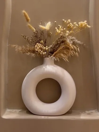 Art is everywhere in the studio. This minimalist donut vase with dried flowers is one of the many small details that make the space feel special and curated.