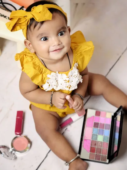 A close-up on our little makeup lover. Her sweet smile and the colorful eyeshadow palette make for an adorable and vibrant shot.