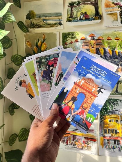 Holding a fan of pages from the Ghibli calendar. You can see the variety of scenes and colors that I've included, each telling a different story.