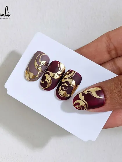 A close-up of a foil and swirl design on my own nail. This technique adds a touch of regal elegance to any manicure.