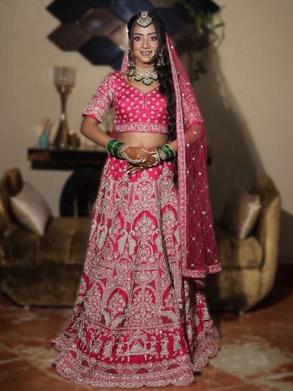 This vibrant pink bridal lehenga is for the bride who wants to stand out. The intricate silver embroidery and full skirt are perfect for making a grand entrance.