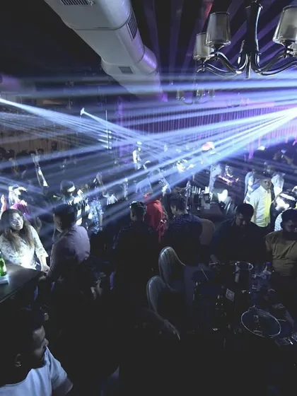 A sea of people under the professional lighting rig. I work with venues to create a truly immersive experience.