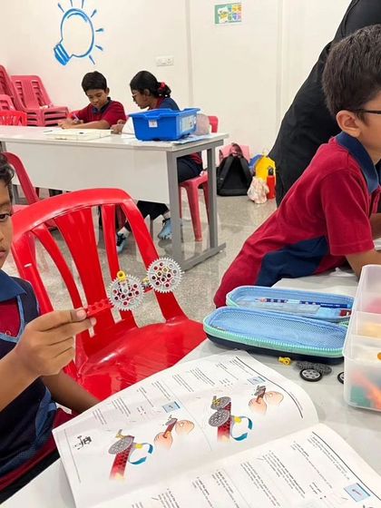 This student from Vidyashilp Academy examines the gear assembly he has just created, learning about how different parts work together.