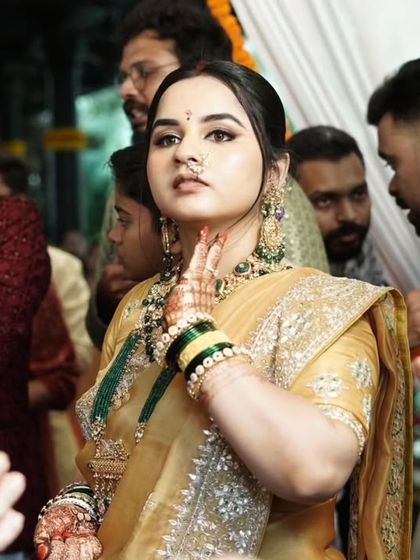 An elegant look for a wedding guest. The golden saree is paired with a subtle smokey eye and a classic updo.