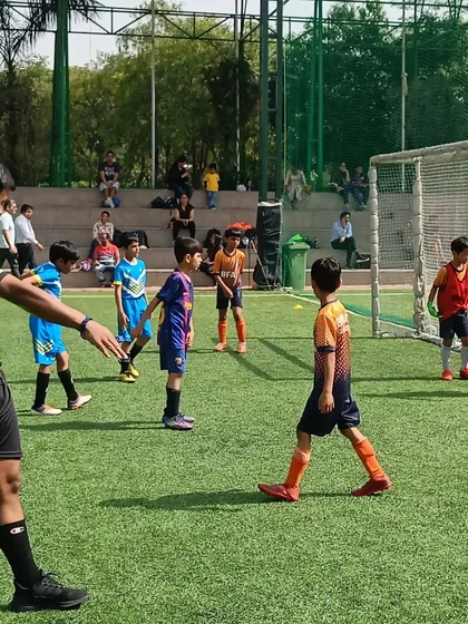 Sportsmanship is a key lesson we teach. Here, players interact with the referee during a match at the Youth Super Cup.