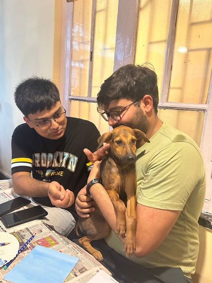 Two participants enjoy the company of a calm, cuddly puppy during the art session.