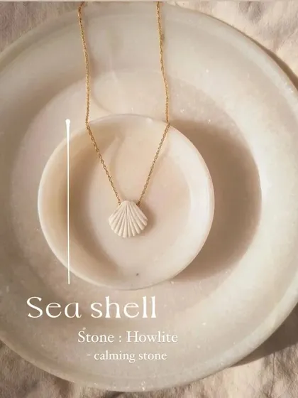 A customer enjoying the beach with my howlite shell pendant. It's the perfect accessory for ocean-inspired tranquility.