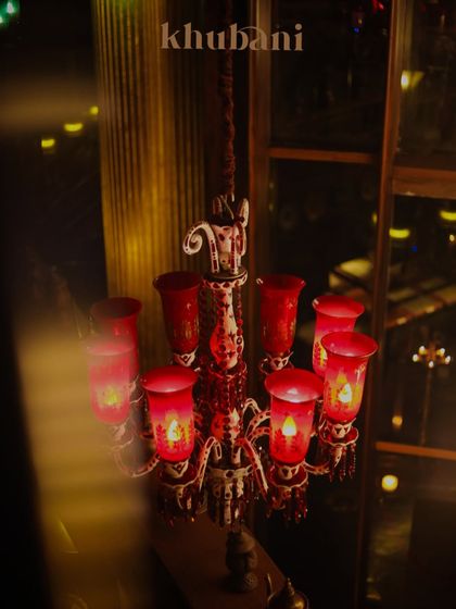 Step into enchantment. This ornate red chandelier casts a warm, royal glow, turning every evening into a regal affair.