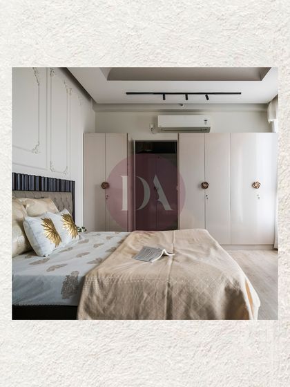 A wider view of the master bedroom, showing the full-height white wardrobes with custom hardware. The design balances classic elements like wall molding with modern track lighting.