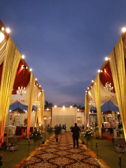 A wide-angle shot of a grand entrance pathway at dusk, with the lights just beginning to glow, creating a magical atmosphere.