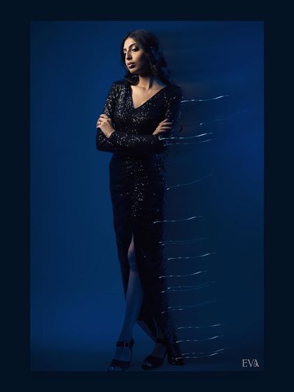 A full-length shot of the model in a black sequined dress, with light trails creating a sense of motion. This technique adds a dynamic and futuristic feel to the studio portrait.