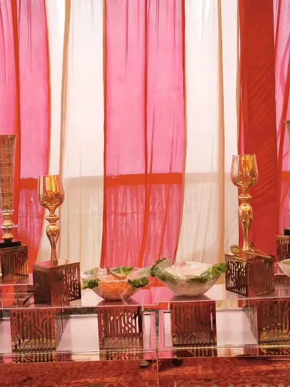 A detailed shot of our salad bar with decorative golden goblets and bowls. The contrast between the red and white drapes and the ornate counter creates a visually appealing food station.