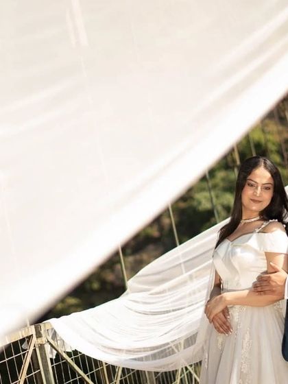 The delicate, sheer fabric of the veil trail creates a beautiful, soft-focus effect in this romantic pre-wedding portrait.