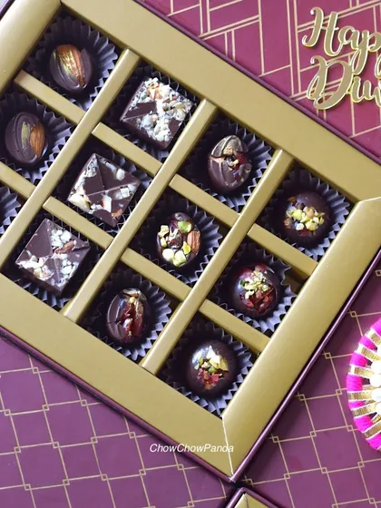 A closer look inside one of my premium Diwali gift boxes. This assortment features homemade assorted chocolate truffles, including pistachio and almond varieties, presented in an elegant purple and gold box.