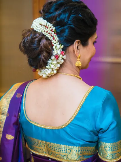 A classic and elegant messy bun adorned with a beautiful gajra. This hairstyle is perfect for a traditional look, like for this naming ceremony.