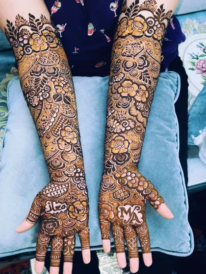 This bridal design was personalized with the groom's name, 'Maaz', and the couple's initials, 'MA', on the palms.