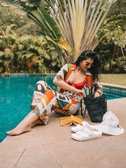 A candid moment by the pool, getting my essentials out of my bag. It captures the relaxed, vacation vibe of Goa.