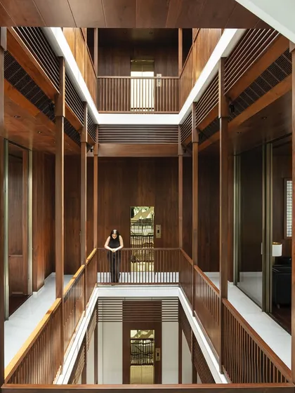 Inspired by the traditional Indian 'wada' or courtyard house, this multi-level atrium forms the heart of the home. Clad in warm timber, it creates visual and aural connections across floors, allowing light and life to flow through the entire structure, fostering a sense of togetherness for the family.