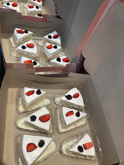 Slices of my famous Milk Cake Pastry, individually packaged and boxed up for a bulk order. This is a fantastic option for corporate events, parties, or large family gatherings.
