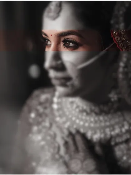 An artistic and modern bridal portrait, using a creative color-splash effect on a black and white image to draw attention to the bride's powerful gaze.