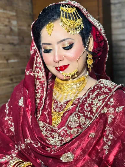 A soft, beautiful pose from this Nikkah bride. The makeup is flawless, with a glowing base, golden eyes, and a classic red lip that makes her look absolutely radiant.