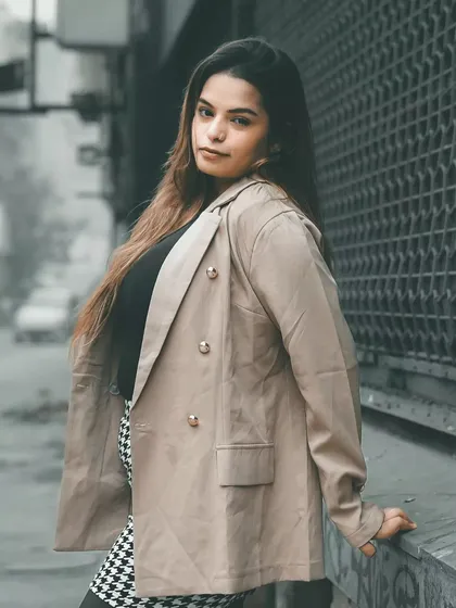Using the texture of the metal gate as a backdrop, this portrait has a distinctly urban feel. The model's pose is relaxed but confident, perfect for a street style feature.
