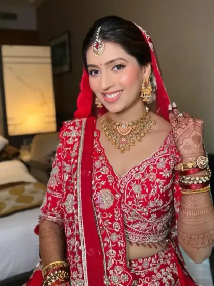 A beautiful bride in her full wedding attire. Her mehndi, with its rich dark stain, perfectly complements her stunning red lehenga.