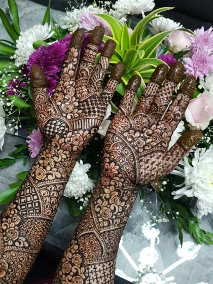 An intricate Indian henna design for a "baat pakki" ceremony, featuring beautiful florals and checkerboard fills.