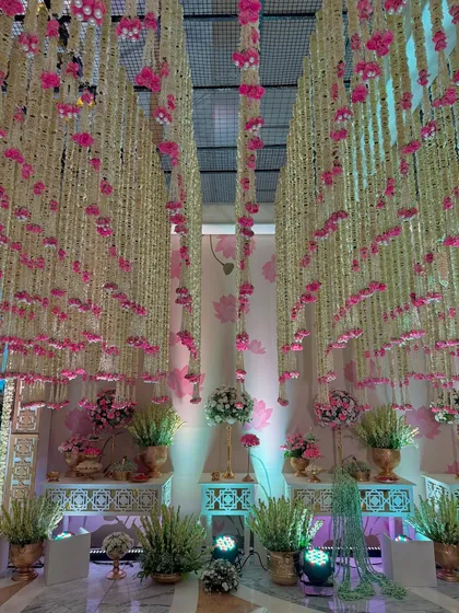 More views of the magical entrance, highlighting the density of the floral ceiling, the elegant decor pieces, and the soft, inviting lighting.