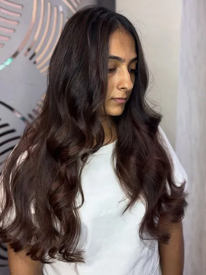 A candid shot of the client enjoying her new mahogany brown hair. The color looks beautiful in natural light, showing off its subtle red undertones.