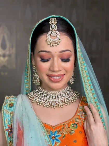 Sometimes, a single statement choker is all you need. This elegant pearl and polki choker with a matching chandbali-style maang tikka creates a sophisticated and regal look, perfect for a reception or engagement.