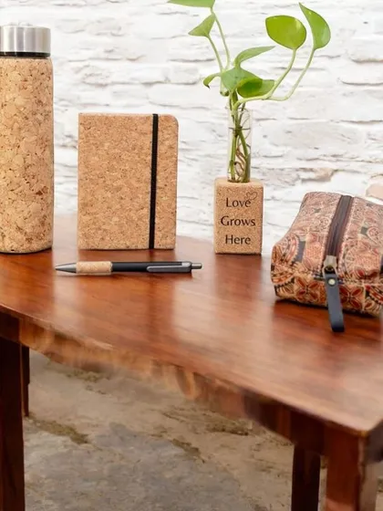 An assortment of my eco-friendly products made from sustainable cork. This set includes a water bottle, notebook, pen, plant holder, and a printed pouch, perfect for an environmentally conscious gift.