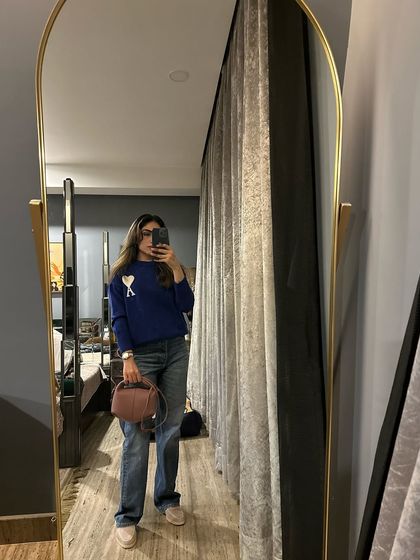 A casual winter outfit featuring a blue sweater and baggy jeans. This is a comfortable and easy look for a relaxed day.