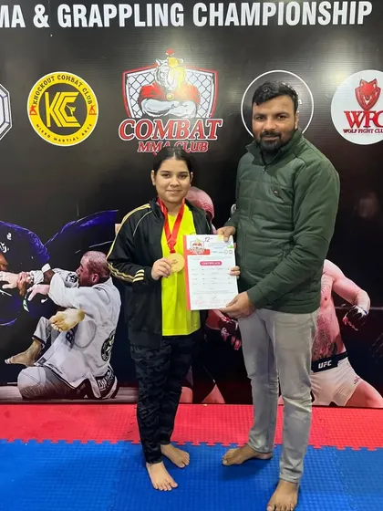 Our female fighter proudly displaying her gold medal. We provide a safe and empowering environment for women to train and compete in MMA.