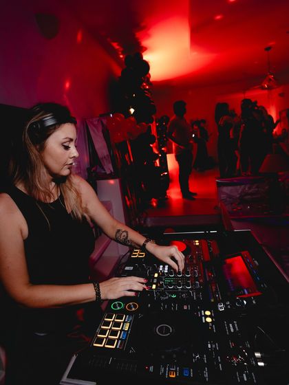 Mixing in a room filled with red light at a private event. I can adapt my setup and vibe for any kind of party.