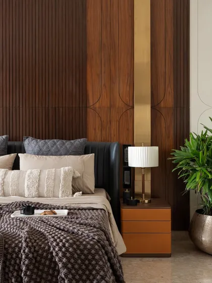 Detail is paramount in our work. This close-up of a bedroom in the Celadon project highlights the intricate craftsmanship of the fluted wood headboard, the warm brass accents, and the rich textures of the bedding, all coming together to create a tactile and serene retreat.