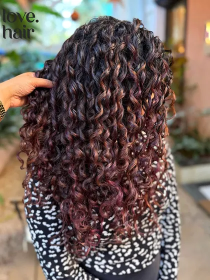 You don't always need bleach for a big impact. Here, we used a no bleach hair colour to create these rich, dimensional purple and red tones, finished with our signature finger coiling technique for maximum definition.