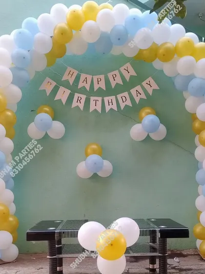 A simple outdoor balloon arch in yellow, blue, and white.